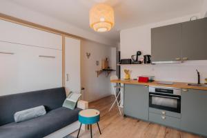 sala de estar con sofá y cocina en RÉPUBLIC’STUDIO AVEC PARKING ! en Nantes