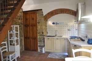 a kitchen with a sink and a wooden door at Caty's little house in Cavriglia