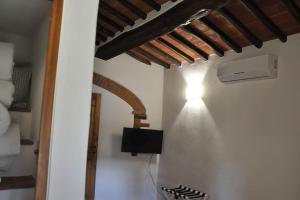 a room with a wall with a heater and a ceiling at Caty's little house in Cavriglia