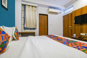 a bedroom with a bed and a television in it at FabHotel Hello Homz in Indore