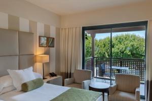 a hotel room with a bed and a balcony at Precise Resort El Rompido-The Hotel in El Rompido