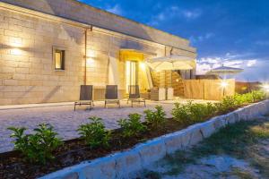 a patio with two chairs and an umbrella at TENUTA DOROLIVO in Otranto