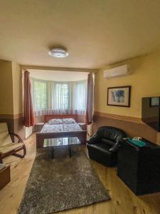 a living room with a bed and a couch at Mátyás Vendégház Siófok in Siófok