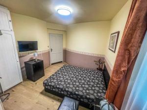 a small room with a bed and a tv at Mátyás Vendégház Siófok in Siófok