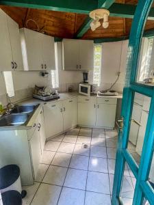 a small kitchen with white cabinets and a sink at Mátyás Vendégház Siófok in Siófok +7 photos