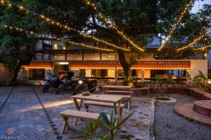 un patio con mesa, bancos y luces en Zostel Kochi (Ernakulam) en Ernakulam