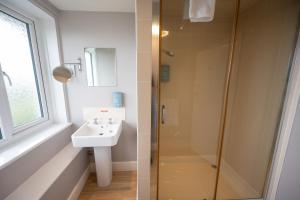 a bathroom with a sink and a shower at Commodore Hotel by Greene King Inns in Bournemouth