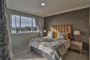 a bedroom with a large bed and a window at Ocean View Apartment - De Bakke Terrace in Mossel Bay