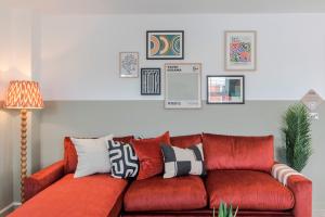 a red couch with pillows on it in a living room at Southwark Serviced Apartments I Your Apartment in London