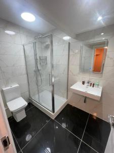 a bathroom with a shower and a toilet and a sink at Acacia Hotel in London