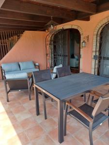 een tafel en stoelen op een patio met een bank bij Casa Evalù in Pula