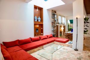 sala de estar con sofá rojo y mesa en Maison MAÏTÉ, au cœur de Biarritz, en Biarritz