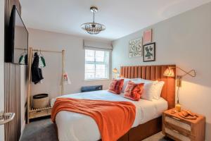a bedroom with a bed with an orange blanket on it at Southwark Serviced Apartments I Your Apartment in London