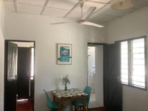 comedor con mesa y ventilador de techo en Ndovu Cottage - Nyali, en Mombasa