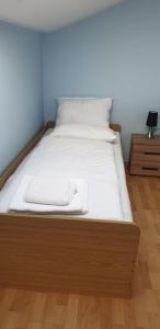 ein Bett mit einem Holzrahmen in einem Zimmer in der Unterkunft GIGA APARTMAN in Jagodina