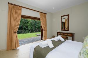 a bedroom with a bed and a large window at San Lameer Villa 403 - 4 Bedroom Luxury - 8 pax - San Lameer Rental Agency in Southbroom +24 photos