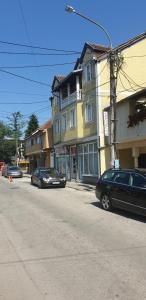 a street with two cars parked in front of buildings at GIGA APARTMAN in Jagodina