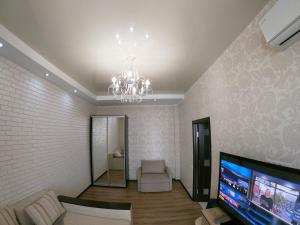 a living room with a chandelier and a tv at Апартаменты на Марсельской, Кадорр, 4я Жемчужина in Odesa