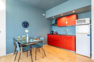 利沃諾的住宿－Waves Paradise Home，厨房配有红色橱柜和桌椅