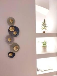 eine Wand mit Platten an einer Wand mit einer Pflanze in der Unterkunft Keramikos at Plateon central Athens apartment by SuperHost Hub in Athen
