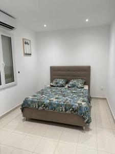 uma cama num quarto branco com piso branco em Appartement en résidence em La Ciotat
