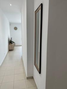 um corredor com um espelho numa parede branca em Appartement en résidence em La Ciotat