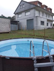 an empty swimming pool in front of a house at CASA MANOLO CAMIÑO DO SANTIAGUIÑO in Vedra