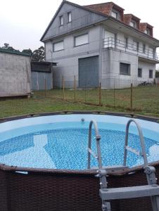 an empty swimming pool in front of a house at Casa Manolo Camiño Do Santiaguiño in Vedra
