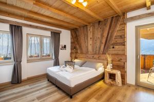 een slaapkamer met een bed in een kamer met houten plafonds bij Miraval Hotel in Coredo