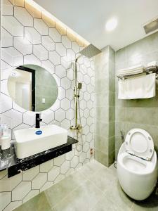 a bathroom with a toilet and a sink and a mirror at Thai Van Home in Ho Chi Minh City