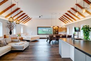 una sala de estar con paredes blancas y techos de madera. en außergewöhnliches loft in ehemaligem stallgebäude 