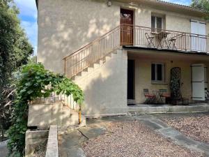 a house with a staircase and a balcony at Casarella Bulle de Paix en Corse Entre Terre et Mer in Lucciana