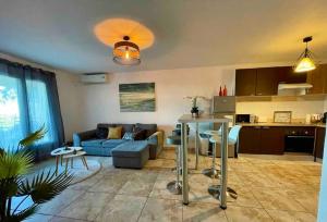 a living room with a blue couch and a kitchen at Casarella Bulle de Paix en Corse Entre Terre et Mer in Lucciana +29 photos