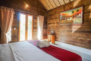 - une chambre avec un lit et une peinture murale dans l'établissement Penida Lapaya Bungalows Nusa Penida, à Nusa Penida