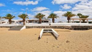 a picnic table on the beach in front of a house at Apartamento, Arena, Primera linea Mar, sea views in Playa Honda