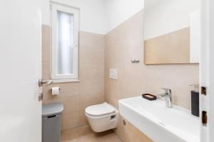 une salle de bain avec toilettes, lavabo et miroir dans l'établissement Sunny Aura - travel & work - with parking, à Pula 29 autres photos