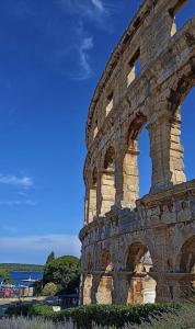 un bâtiment avec des arches sur le côté dans l'établissement Sunny Aura - travel & work - with parking, à Pula