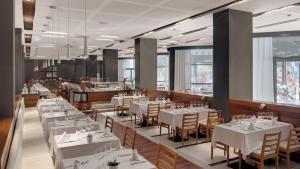 a dining room with white tables and chairs at Precise Resort El Rompido-The Hotel in El Rompido