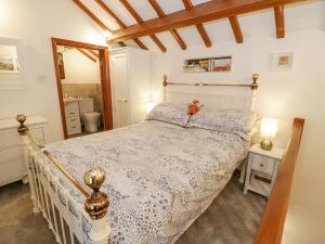 a bedroom with a bed in a room at The Little White Cottage in Llanferres