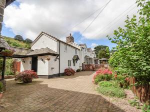 uma fila de casas brancas numa entrada de tijolos em The Little White Cottage em Llanferres