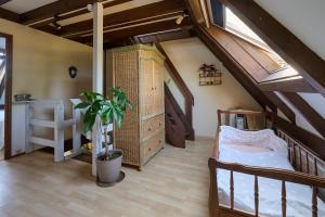 a attic room with a bed and a staircase at Le Tonneau Bleu - Appt avec piscine partagée in Lembach