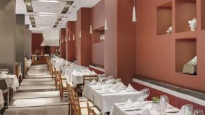 a dining room with white tables and chairs at Precise Resort El Rompido-The Hotel in El Rompido
