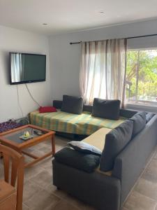 uma sala de estar com um sofá e uma mesa em Casa con vista y jardín, a 20' de la playa em Sant Cebrià de Vallalta
