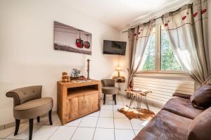 ein Wohnzimmer mit einer Couch und einem Fenster in der Unterkunft Au Rêve Savoyard 5 - 4 personnes in Morillon