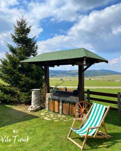 a chair and a gazebo next to a chair sidx sidx sidx sidx at Vila Tornik in Zlatibor