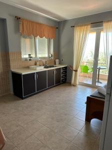 a kitchen with a sink and a large window at Anna House Dhermi in Dhërmi