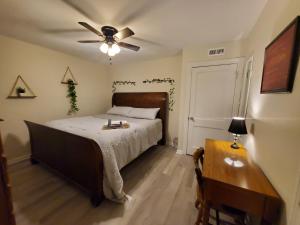 a bedroom with a bed with a ceiling fan and a table at Room Near Downtown UofL,Airport&ExpoCenter in Louisville