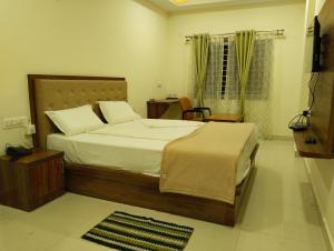 sypialnia z dużym łóżkiem w pokoju w obiekcie Sambhrama Residency w mieście Shivamogga