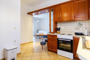 - une cuisine avec des placards en bois et une cuisinière dans l'établissement Savvitsa's Apartment, à Corfou