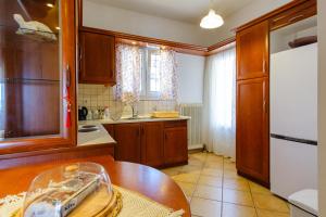 une cuisine avec une table en bois et un réfrigérateur blanc dans l'établissement Savvitsa's Apartment, à Corfou